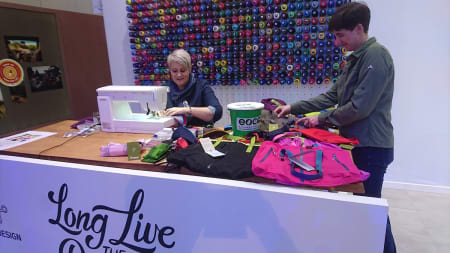 SØM: Bergans stilte med symaskin og ødelagte jakker sydd om til bæreposer. Helt riktig på ISPO 2018.