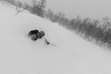 DYPT: En meget fornøyd Endre Hals kjører i pudder som er så dyp at den når over hans egen hals. Bildet ble tatt torsdag første desember. Foto: Tore Meirik