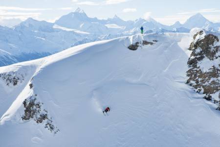 MIDT I SMØRØYET: Trygve Sande setter fart i toppen av et langt run på baksiden av skisenteret i Leukerbad. I bakgrunnen ses noen av Alpenes høyeste og mest ikoniske fjell. Weisshorn (4 506 moh), Zinal Rothorn (4 221 moh), Matterhorn (4 478 moh) og Dent Blanche (4 357 moh) ses bak Kilian Roten. Foto: Tore Meirik