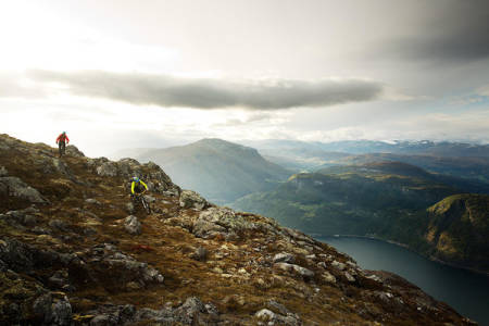 BRATT FJORDSYKLING: Stig Wigum og Knut Myking utnytter de siste glimtene med kveldssol til å sette fart ned mot Sogndal fra Storhaugen. Foto: Kristoffer H. Kippernes
