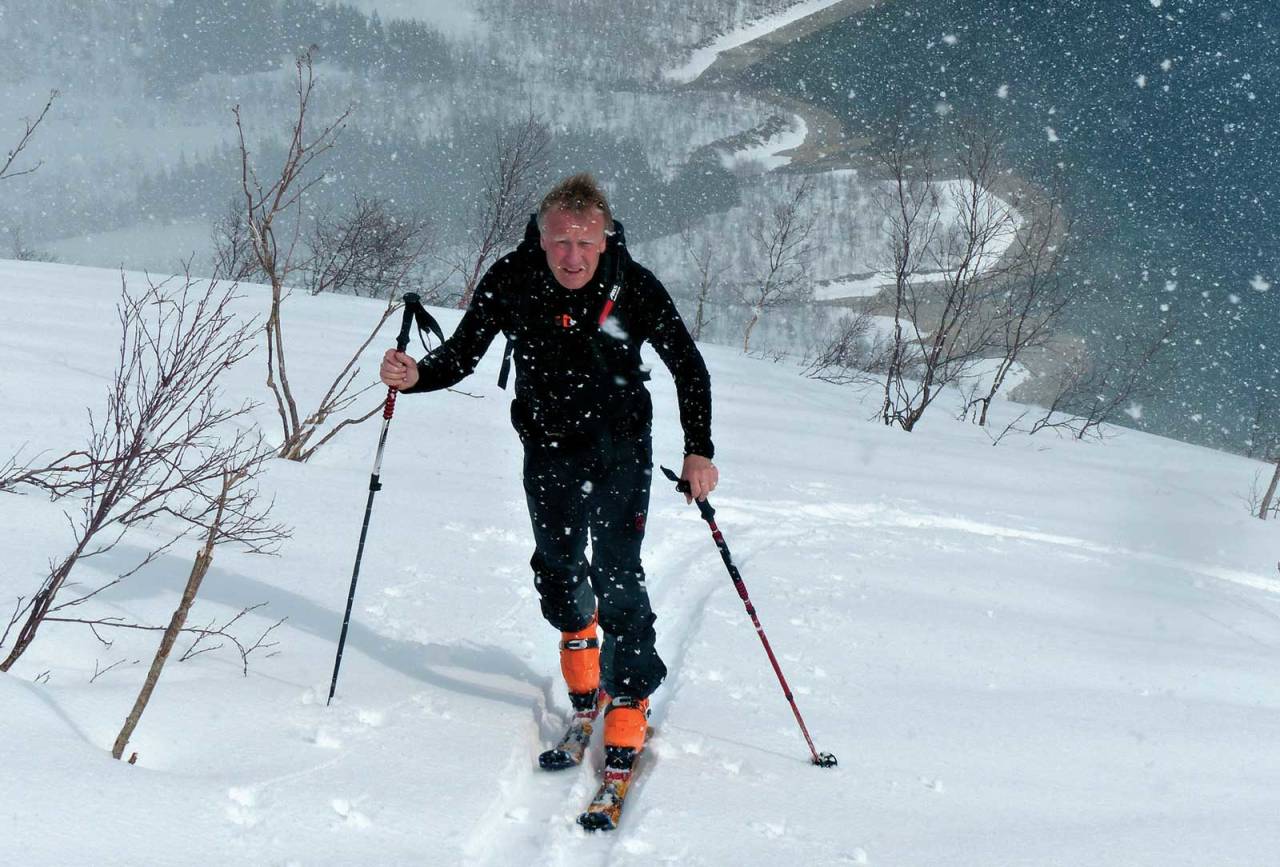 Thomas Lhose i skiftende aprilvær over Einarvika med sikte på Torneshatten. Foto: Tor Erik Slette. / Toppturer rundt Bodø.