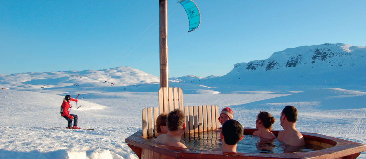 Utenfor Haukeliseter fjellstue frister villmarkspaet etter en lang dag på tur. Her finner du både stamp og badstu. Husk lue! Foto: Haukeliseter Fjellstue. / Toppturer i Sørvest.
