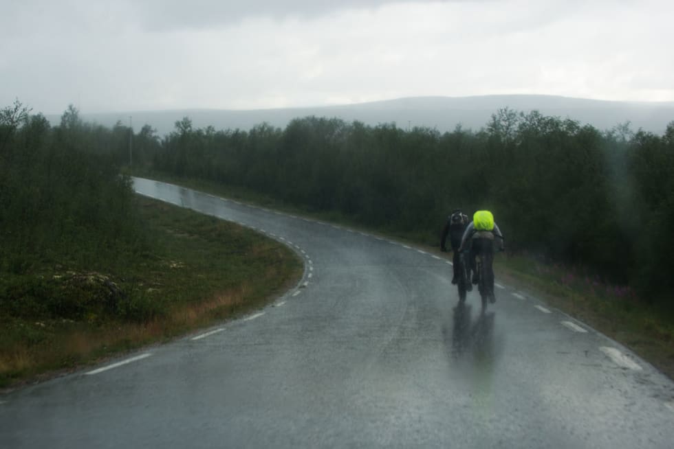 NORSK SOMMER: En norsk sommer kan virkelig gi deg alle fire årstider. Her banker Les og Paw Ager inn mot Kautokeino på det siste asfaltpartiet i slagregn. DSC_8341