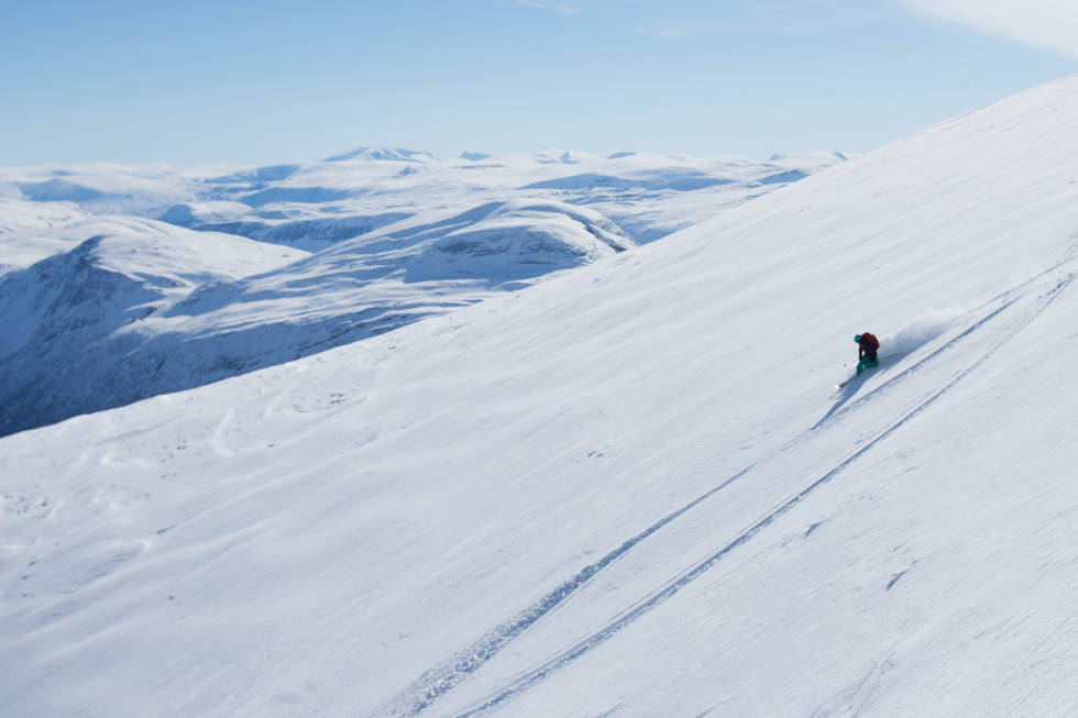 BLANDINGS: Innlandsfjellet Snøhetta (2287 moh) ruver i bakgrunnen mens Line Marie Drøpping setter elegante telemarksvinger ned fra Kongskrona, som ligger et steinkast fra fjorden. Foto: Tore Meirik Snøhetta