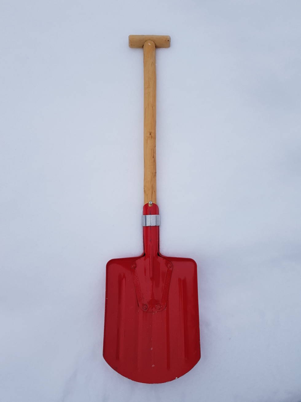Turspade med aluminiumblad med bøyd profil for ekstra styrke og trehåndtak. Fordelen med trehåndtak er at det leder mindre kulde enn metall, og det kan repareres eller byttes ut. Denne har fått nytt treskaft med T-grep. Ulempen med denne klassiske spaden er at bladet er lite, og at koblinga mellom skaft/blad kan være plundrete. Foto: Christer Lundberg Nes Rottefella turspade