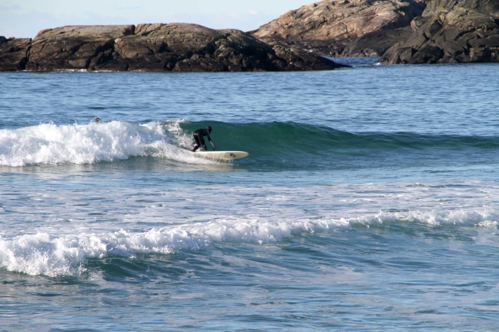 Odin Røhrt, 13 år, har funnet frem longboardet. Perfekt når bølgene blir litt mindre. Foto: Audun Holmøy Røhrt