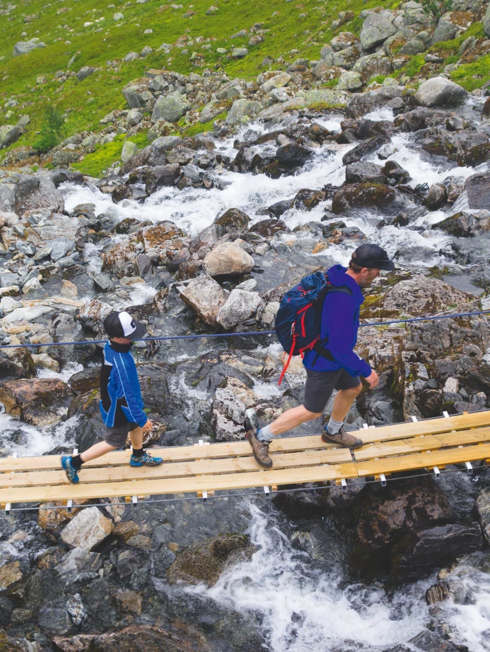 HVEM TRAMPER: Hjalmar (7) og Jørgen Aamot på vei over elva innerst i Øvredalen. Foto: Erlend Sande