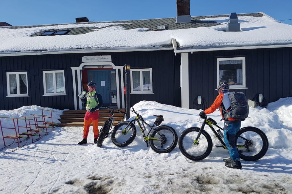 I godvær blir det pause i solveggen på hytter langs etappene, men i dårlig vær gir de mulighet til å søke ly. Her nyter Lars Harald Blomkvist og Trond Olsen lunsj ved Gargia Fjellstue. Foto: Stig R. Nilsen Dagens lunsj tok vi ved Gargia Fjellstue - Lars Harald Blomkvist og Trond Olsen Foto - Stig R Nilsen 1400x933