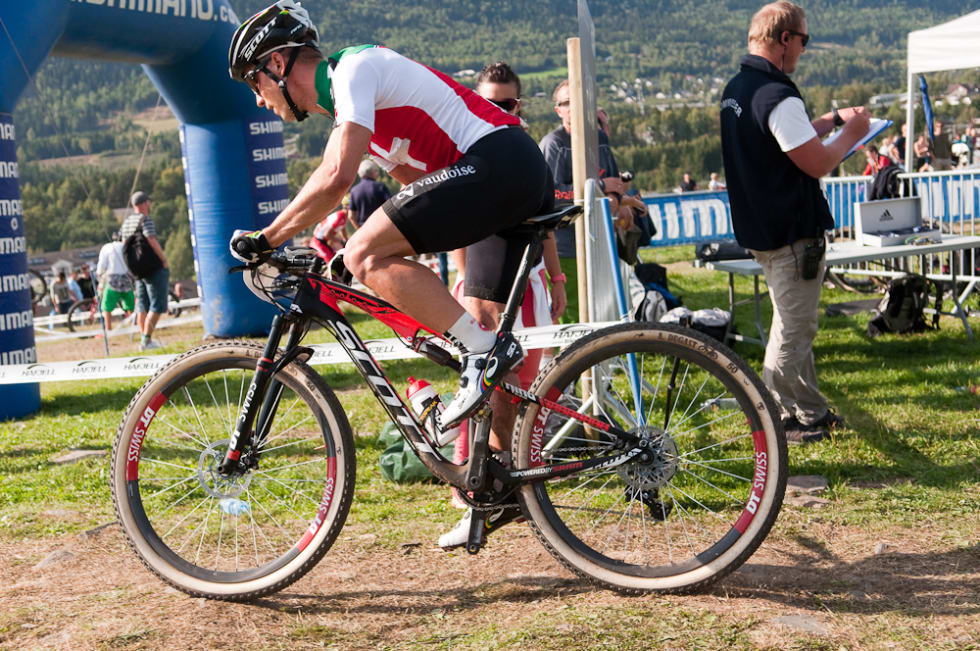 HET PÅ GRØTEN: Nino Schurter gikk i tet direkte fra start, men måtte etter hvert gi tapt for suverene Absalon. Foto: Øyvind Aas