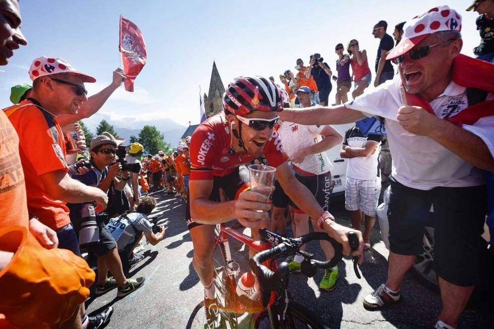 MOROKLUMP: Adam Hansen er i tillegg til et geni en skikkelig moroklump. Han gjorde det etterhvert til en tradisjon å skåle med fansen mot slutten av Tour de France. Foto: Cor Vos. adam-hansen