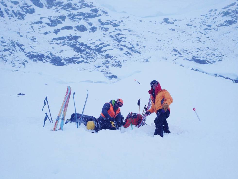 DRAMATISK: Dette er Alberts egent bilde fra den krevende redningsaksjonen da to svenske skikjørere datt utfor på fjellet Loftet i 2016. Ulf Ryen fra den alpine redningsgruppa til venstre og redningsmann Christen Tellefsen jobber med utstyret etter at de to falt ned stupet i bakgrunnen. Bilde: Albert Lunde Albert-Lunde-Portrett-3