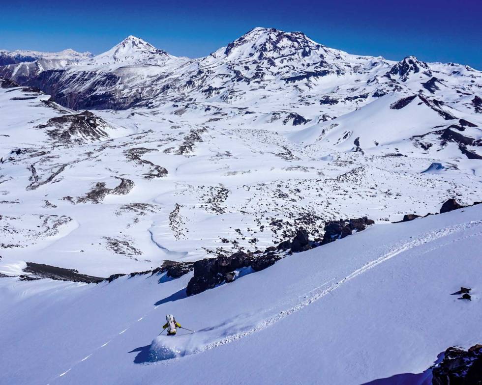 ENDELIG: Etter 36 timer værfast i teltet nyter Kaj litt nysnø på det som er sannynligvis første nedkjøringen av Volcan Descabazedo Chico. Volcan Descabazedo Grande og Cerro Azul er i bakgrunnen. Alto-Cinco-Ski-Sør-Amerika-7