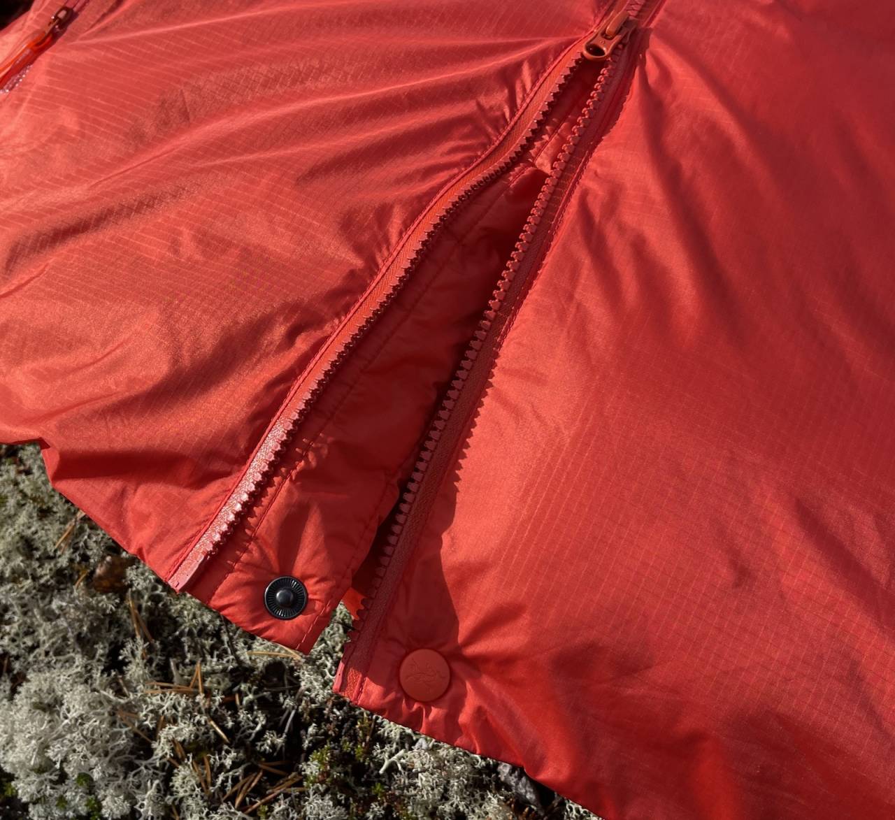 Toveis: Arc'Teryx Alpha Parka med knapp under toveis glidelås. Dette er veldig bra når man sikrer en klatrer, siden glidelåsen må trekkes opp for å komme til selen. Arc'Teryx Alpha Parka glidelås