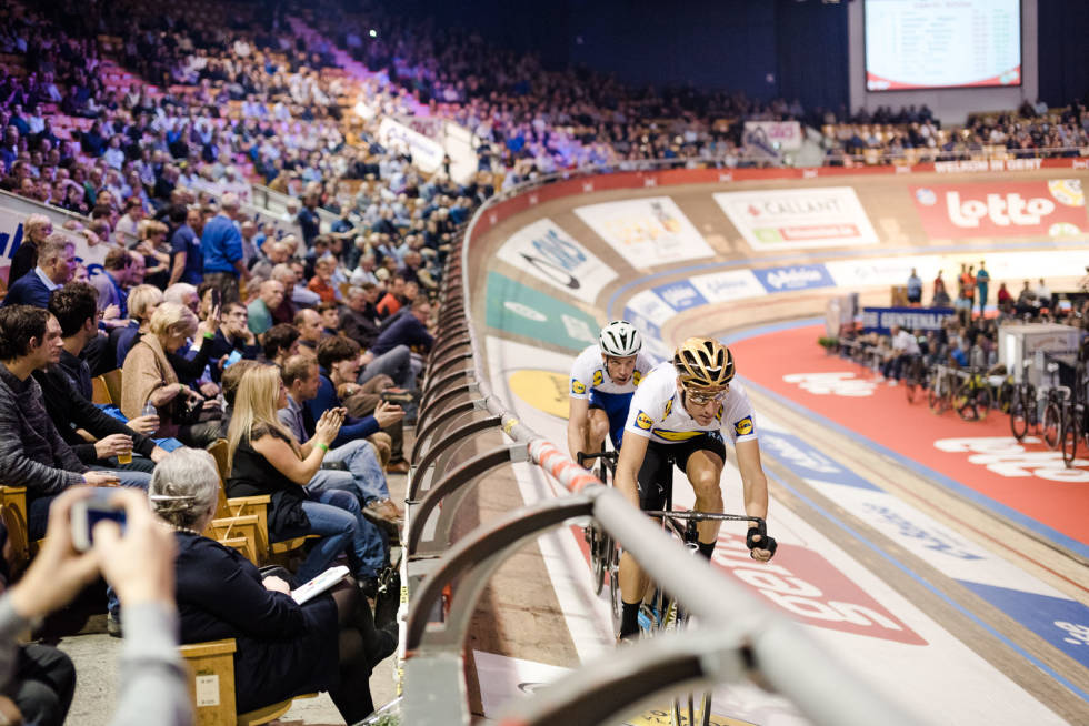 I YTTERKANT: Iljo Keisse og Elia Viviani varmer rolig opp ytterst i banen, mens andre varmer opp i høyere hastighet nedenfor den blå linjen. Foto: Henrik Alpers. bane-43