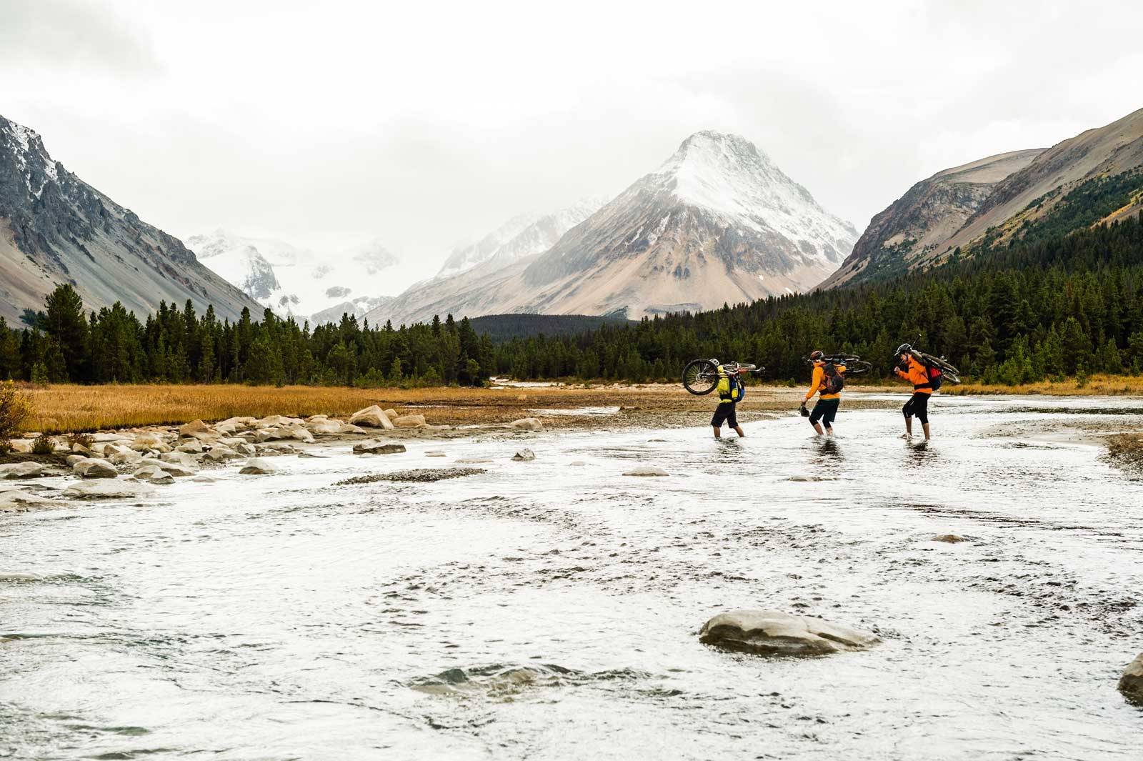 VÅT PÅ BEINA: Anthony Bonello, Ross Measures, og Stephen Matthews krysser en elv med iskaldt brevann. Chilcotins-Canada-Stisykling-10