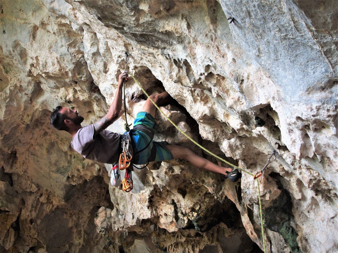 MALANGA HASTA LA MUERTE: Adrian Perez Martinez, alias El Flaco (Han tynne) danser lekende lett opp ruta «Malanga Hasta la Muerte» (7b+) i La Cueva de la Vaca (Kugrotta) i Viñales. Den lokale bondesønnen har valgt klatring, og dermed kalk framfor jord på hendene. Rutenavnet kan oversettes med «Malanga (= en vanlig grønnsak) til døden», kanskje en aldri så liten parodi på et revolusjonært slagord? Foto: Ingrid Fadnes Cuba klatring fjellklatring