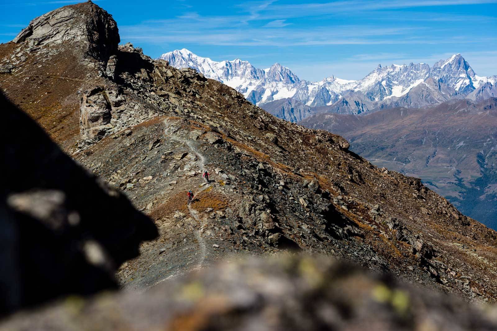 Baksiden: Holger Meyer og Karen Eller nyter en fantastisk stisnutt underveis på en lang tur mellom Pila og Cogne. I bakgrunnen ligger det vakre Mont Blanc-massivet, med Mont Blanc (4810moh)lang til venstre, og Grandes Jorasses (4208moh) til høyre. Guide-til-stisykling-i-Alpene-10