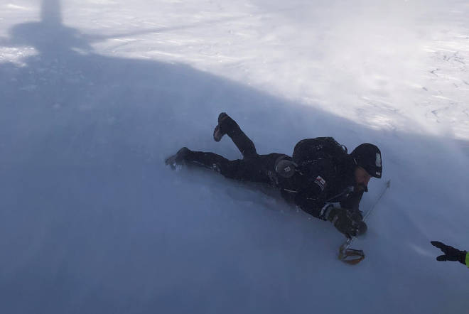 HER BLIR HAN REDDET: Remi Grinius strekker hånda ut til redningsmannen etter en kald natt i teltet. Foto: Hovedredningssentralen redning jotunheimen
