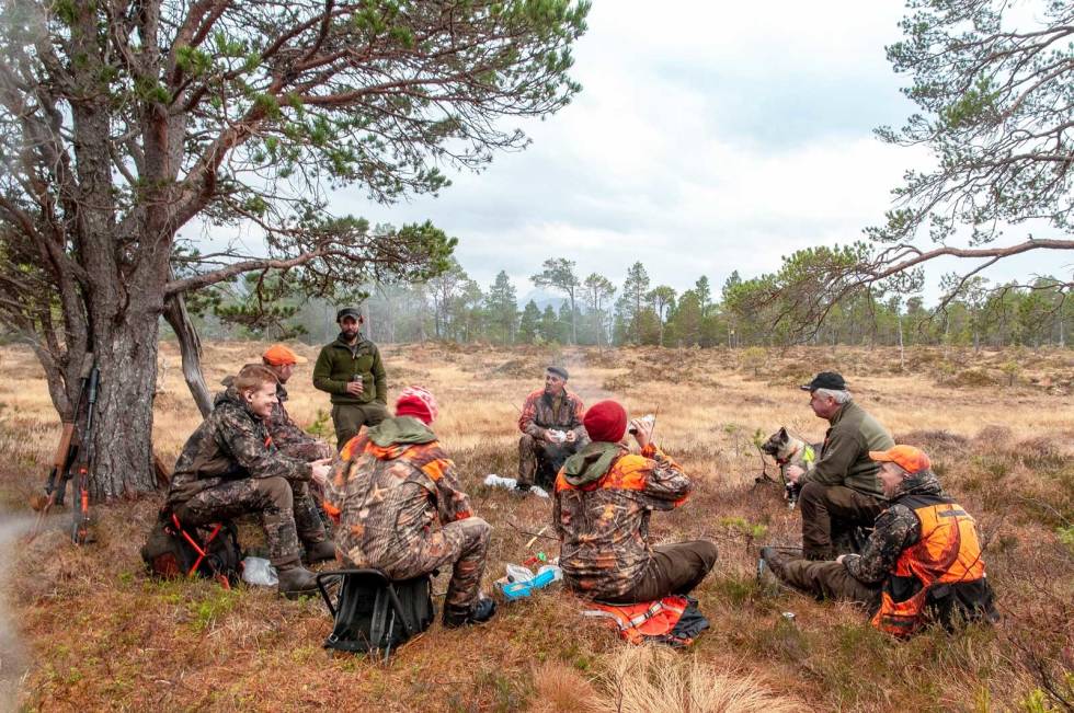 BÅLKOS: Østfold-delegasjonen er tydelig på at de ikke er her for å skyte flest mulig dyr, så her er det god tid til samling rundt kaffebålet. Fra venstre Sigbjørn Skar, Ove Meisingset, Tomas Holmeide (stående), Arne Andsnes (med ryggen til), Lars Sandli, Trond Arild Fjellengen Røttingsnes (med ryggen til), Morten Nordli og Magnus Karlson. Nordmøre-Hjortejakt-6