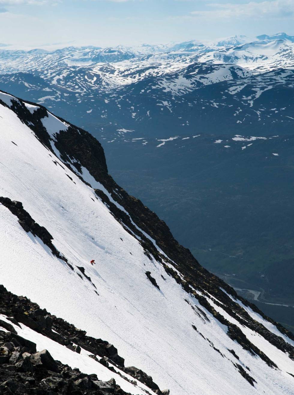 BRATT I TOPPEN: Artikkelforfatteren prøver å se kul ut i det temmelig bratte toppartiet i Nyskridugrove. Under seg har han 1400 høydemeter sommerlig og heisbasert frikjøring. Bøver-dalen i bakgrunnen. Foto: Henrik Ulleland Juvass-frikjoering