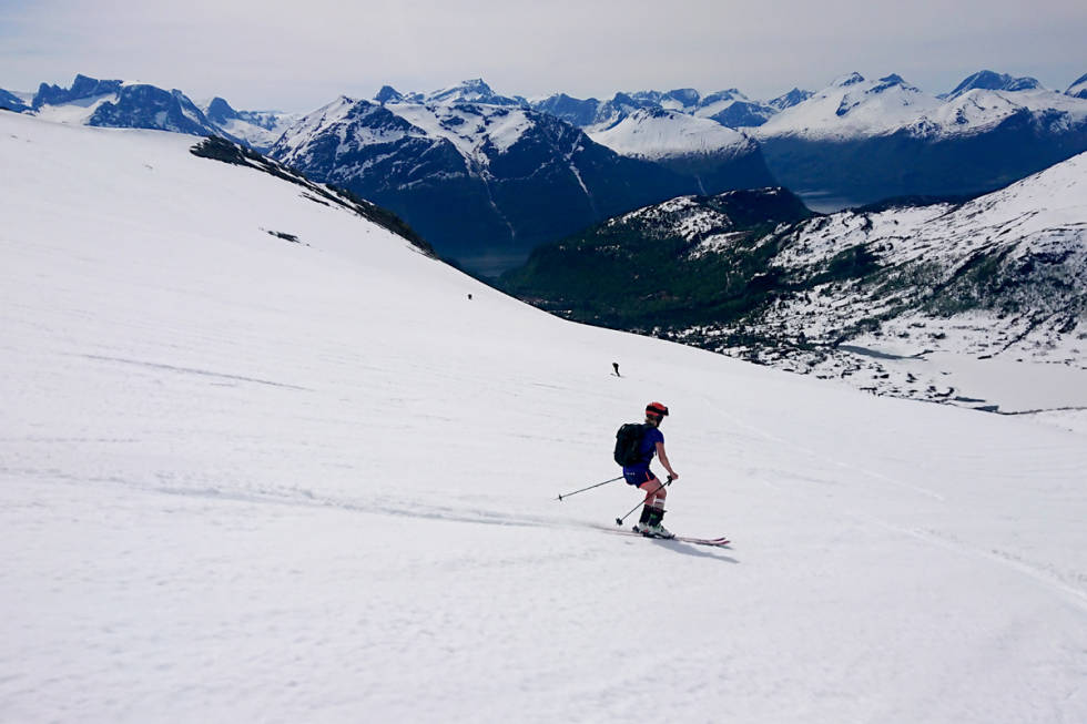 Shorts og T-skjorte og bøttevis med solkrem erstatter skalljakka på tur. Gjertrud Fallet på ski ned fra Smørbottinden. Foto: Adam Tumidajewicz Romsdalen vårski tur topptur randonee utemagasinet fri flyt halvor hagen tindevegleder nonstind alnestind