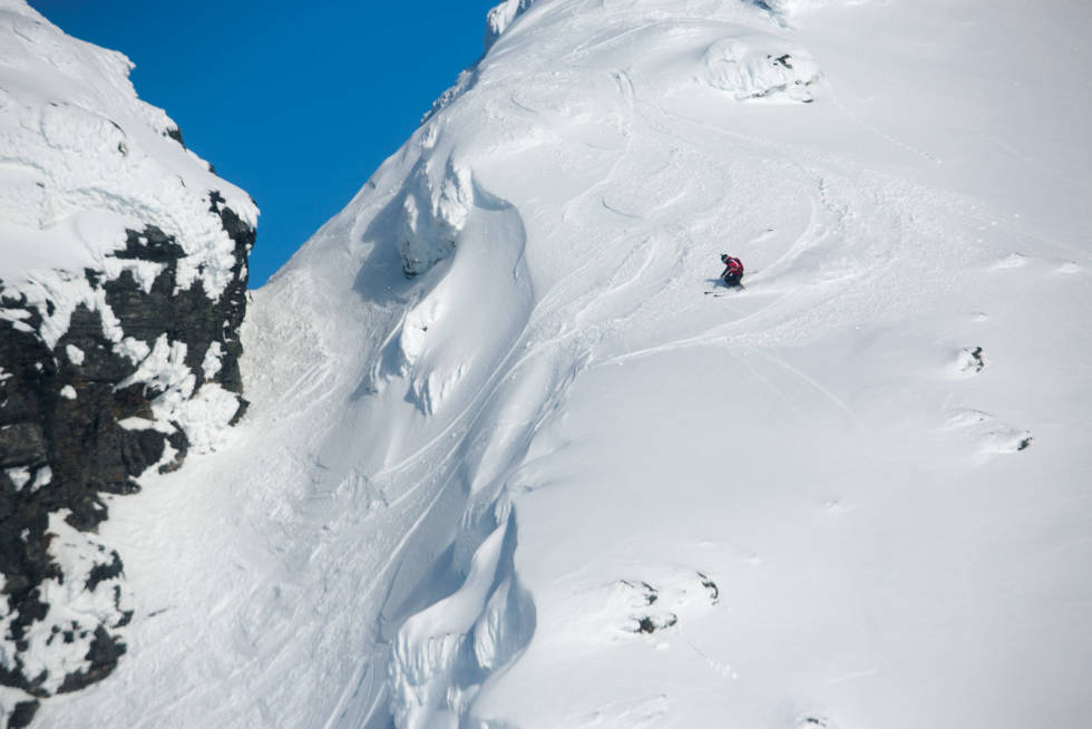Frikjører på Andørja Freeride sikter seg inn på “Bananene”. På andre siden, laveste punkt på bildet, starter nordøstrenna. Foto: Tore Meirik Snøtinden-Andørja-4