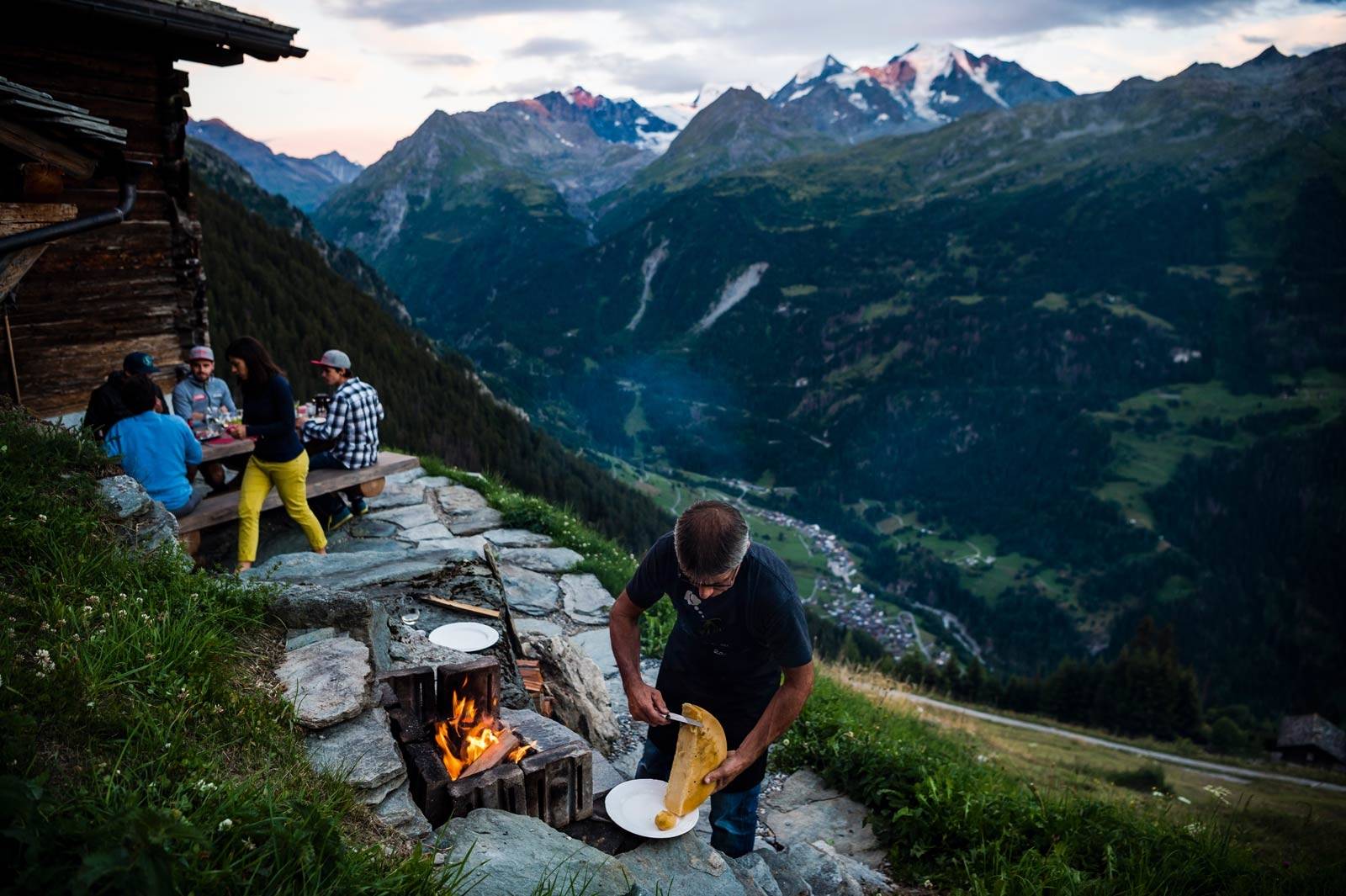 GAMMELT MØTER NYTT: I Valais lever tradisjon og historie i symbiose med det moderne samfunnet. Til venstre; topp moderne stisykkel i karbon, ved et flere hundre år gammelt hus. Til høyre: Tradisjonell Raclette-middag ved en fjellhytte over Verbier etter en lang dag på sykkelen. Stisykling-i-Sveits-11