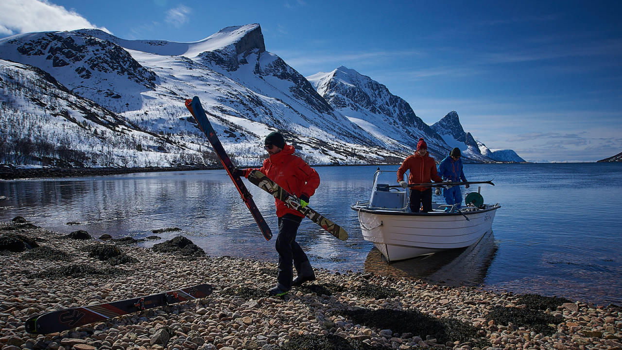 Lossing av skiutstyr på stranda helt i bunn av fjorden. Vi har spennende tinder på alle kanter. Det er tid for å velge hvilken vi skal satse på. Foto: Svein Petter Aagard topptur på senja indre selfjord