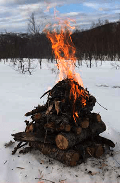 Fra toppen: Slik kan et vinterbål settes opp. Det viktige er å isolere selve bålet fra snøen. Dette gjøres med vanlige, gjerne fuktige, vedkubber. Foto: Håvard Lium topptent vinterbål