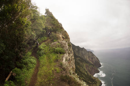 PÅ KANTEN: Madeira er en opplevelse i seg selv, med eller uten sykkel. John Fernandes leder Knut Lønnqvist ned en sti langs et stup på nordsiden av øya. Med storslagen natur blir det hyppige stopp for å ta omgivelsene inn over seg. Foto: Kristoffer Kippernes